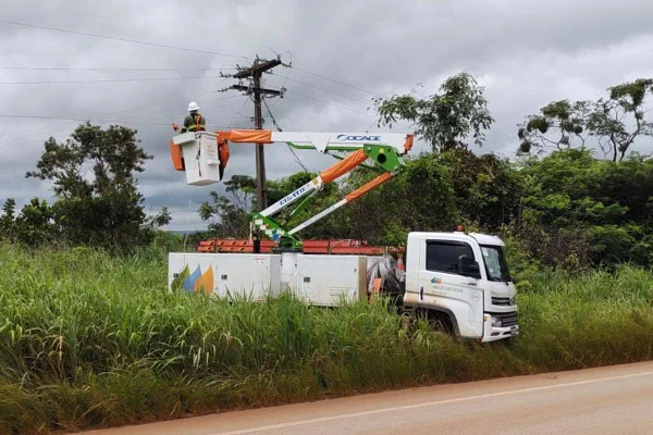 Fotografia colorida mostrando caminhão de empresa de energia com funcionário mexendo em poste-Metrópoles