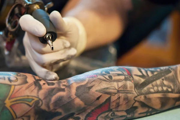 foto colorida de um braço sendo tatuado