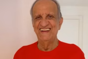 Bemvindo Sequeira posa sorridente de camisa vermelha