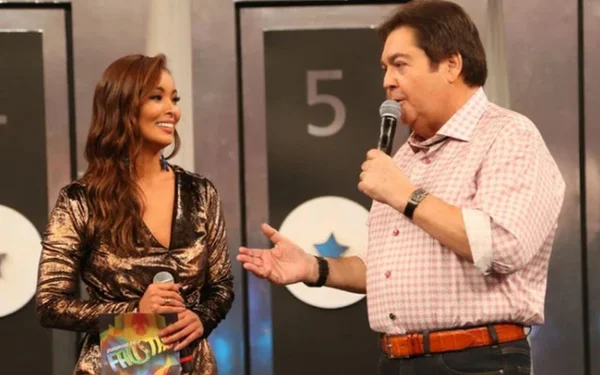 Na foto, Carol Nakamura e Faustão apresentando um programa na TV - Metrópoles