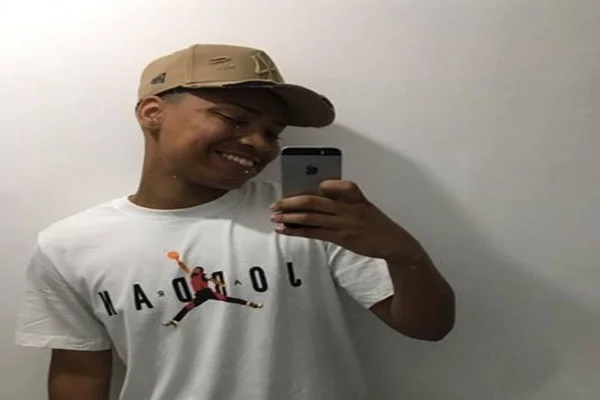 ele posa para foto com um boné