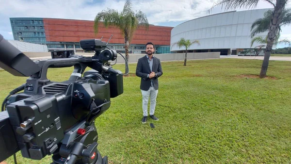 Jornalista em frente à Câmara Legislativa do DF