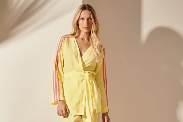 Modelo usa look amarelo com quimono que tem listras em rosa na lateral - Metrópoles