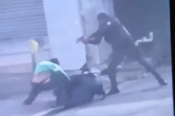 Imagem colorida de PM com arma apontada para homem que reagiu a abordagem policial. Metrópoles