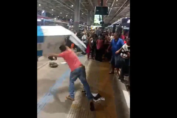 Homem de blusa rosa atira bancada contra o chão
