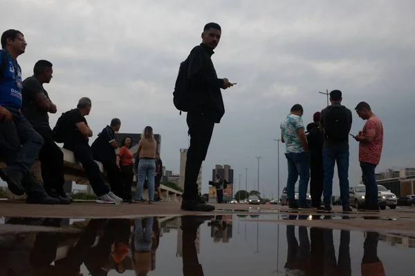 Homem com casaco com uma poça de água em sua frente