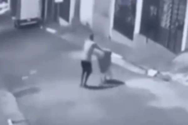 Imagem colorida mostra homem carregando carrinho de supermercado com corpo de mulher. Metrópoles