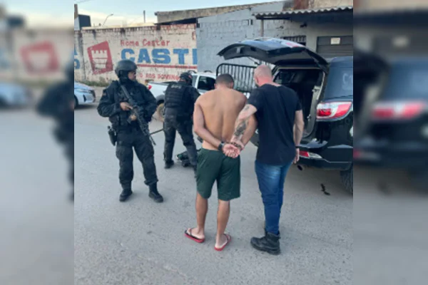 Foto colorida de polícia prendendo homem branco de cabelo curto