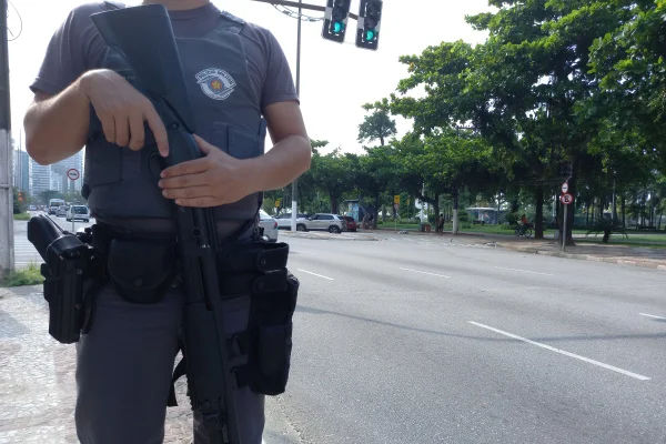 Imagem mostra PM com arma - Metrópoles