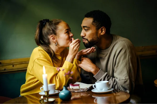 casal comendo em uma sala com fundo verde