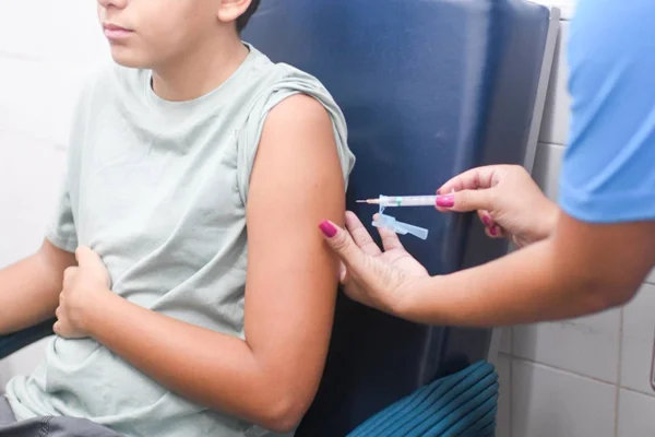 Imagem colorida de uma criança sendo vacinada - metrópoles