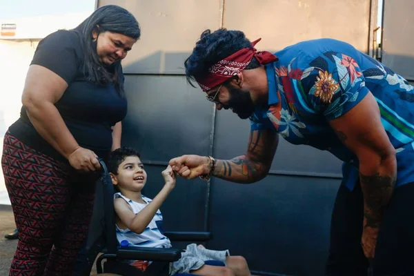 Antes de show, Gusttavo Lima sai do carro e conhece fã com paralisia