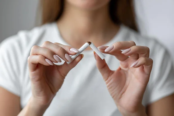 Na foto, uma mulher quebrando o cigarro com a mão - Metrópoles