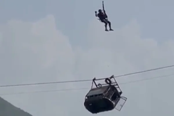 Imagem colorida de equipe resgatando pessoas presas em um teleférico no Paquistão - Metrópoles