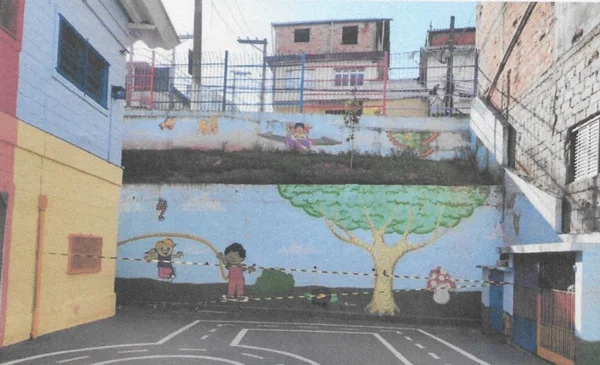Imagem colorida mostra fita zebrada interditando terreno de escola em São Paulo. Muro ao fundo tem desenhos infantis - Metrópoles