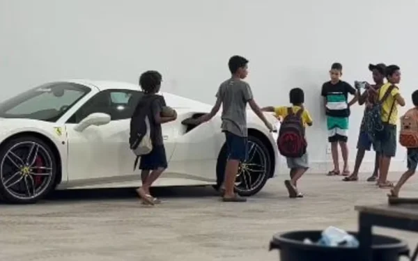 imagem colorida meninos emocionados ao ver ferrari