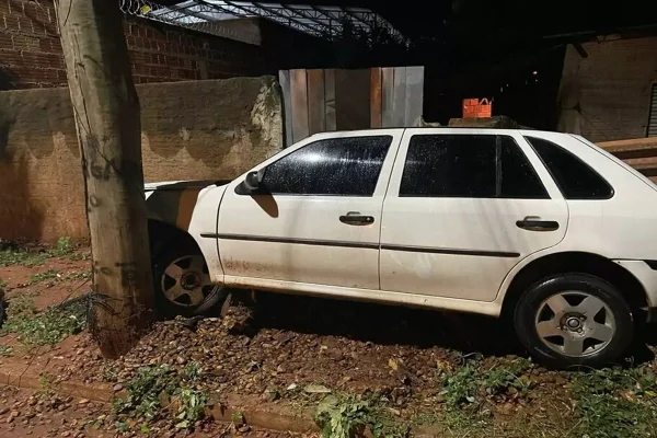Carro branco ao lado do poste