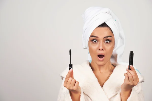 Foto colorida de mulher segurando máscara de cílios