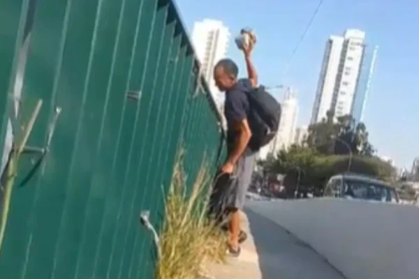 Imagem colorida de homem jogado pedra em veículos na radial leste. Metrópoles
