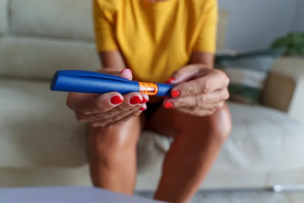 Mulher de meia idade irreconhecível usando caneta de insulina para controlar os níveis de açúcar no sangue