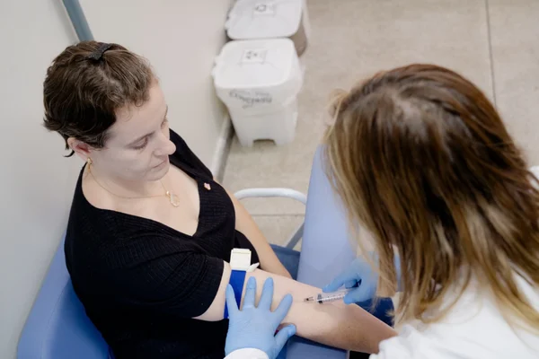 Fotografia colorida mostrando enfermeira tirando sangue de paciente mulher-Metrópoles