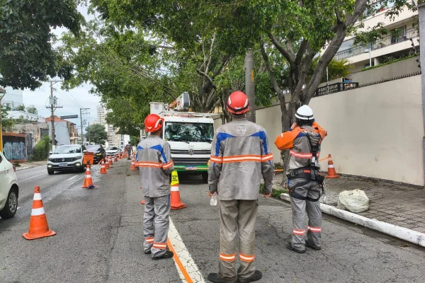 Imagem colorida mostra funcionários da Enel após apagão em SP. Metrópoles