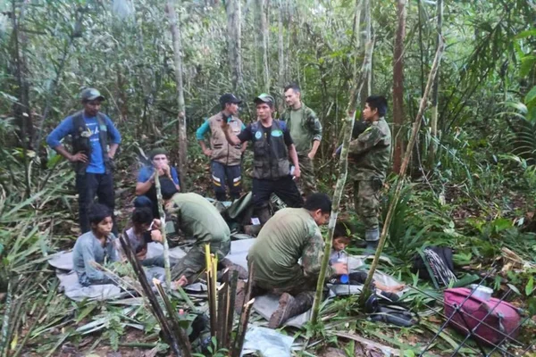 Imagem colorida mostra Resgate de crianças em selva na Colômbia. Além das crianças, aparecem os militares - Metrópoles
