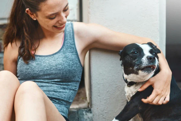 Imagem colorida de cachorro se afastando de mulher