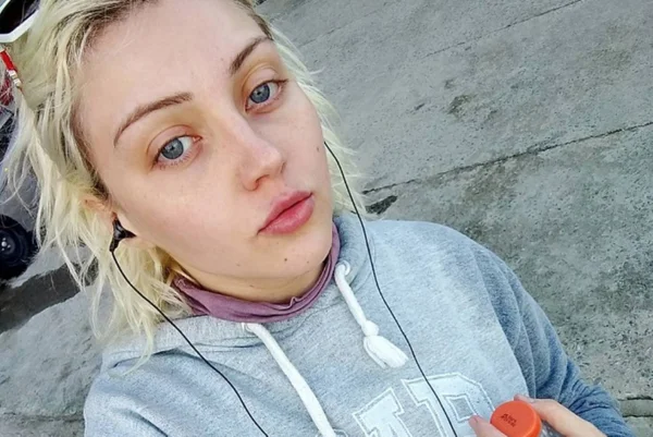 Imagem colorida de mulher loira tirando selfie. Metrópoles