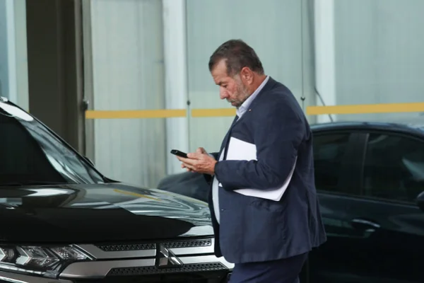 Imagem colorida de Carlos Lupi, atual ministro da Previdência, mexendo no celular - Metrópoles