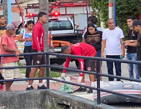 Foto colorida de socorristas recolhendo um feto abandonado em uma vala no RJ - Metrópoles