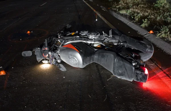 Imagem colorida de moto caída no chão - Metrópoles