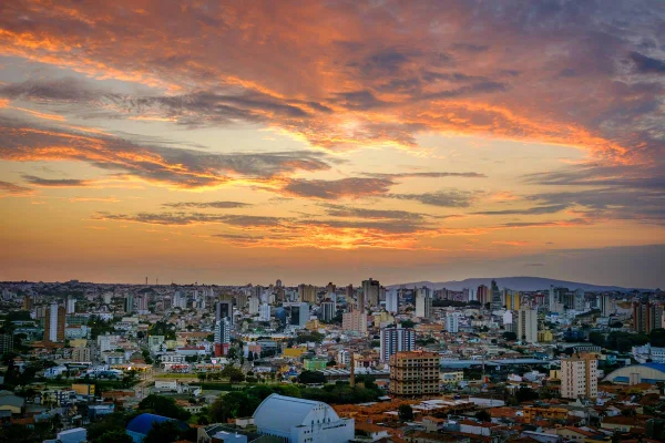 Imagem colorida mostra vista aérea de Sorocaba, com prédios no horizonte, e o sol se pondo ao fundo - Metrópoles