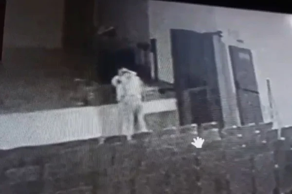 Print de imagem em preto e branco de casal praticando sexo encostado em palco de teatro, as poltronas estão vazias