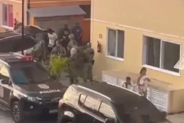 Imagem colorida de policiais prendendo suspeitos. Metrópoles