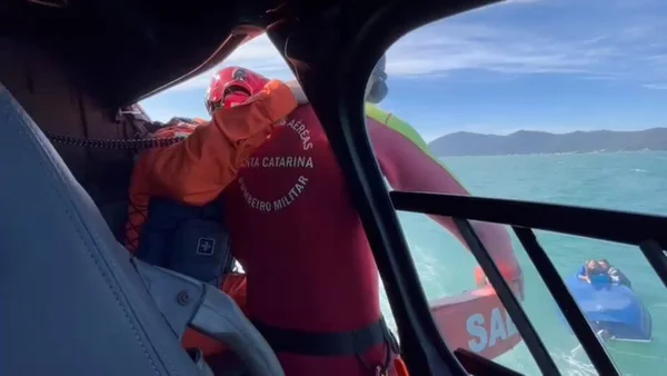 Imagem colorida de bombeiros fazendo o resgate do casal que ficou a deriva em Santa Catarina - Metrópoles
