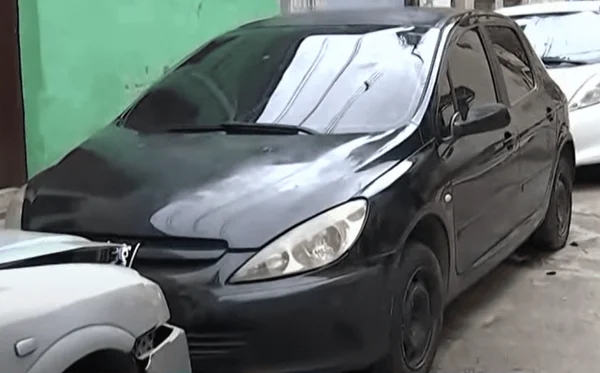 Frente de carro preto abandonado na rua, estacionado entre um carro cinza e um carro branco; dentro dele foi encontrado um corpo em estado de decomposição - Metrópoles