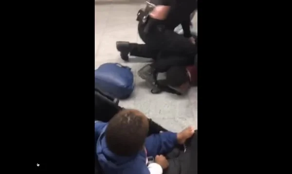 Dois seguranças dão mata-leão em homem negro enquanto bebê que estava com ele assiste a cena