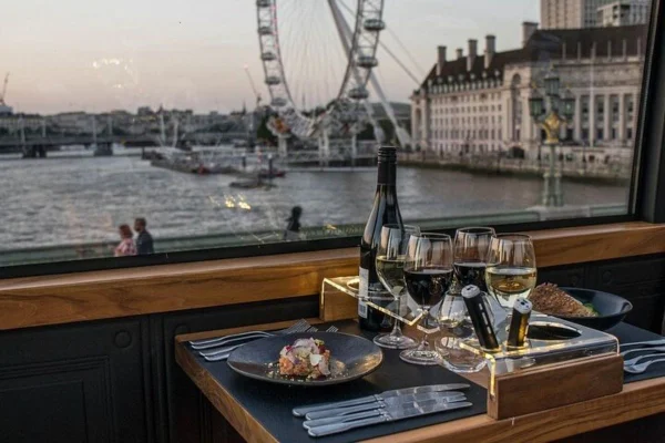 Vista da janela de um restaurante com mesa servida com a roda gigante de Londres de paisagem