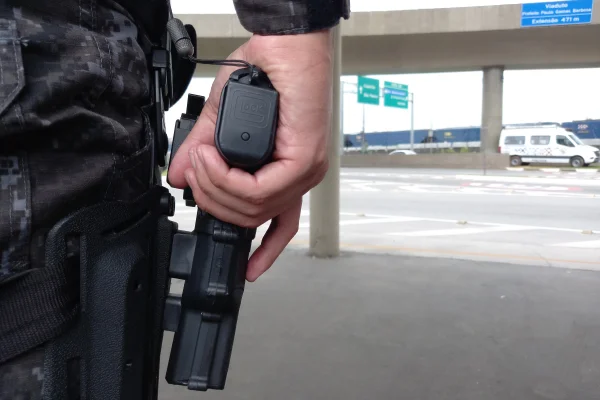 Imagem mostra mão de PMs segurando arma - Metrópoles