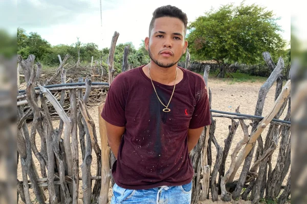 Imagem colorida de um homem vestido com camiseta vinho e bermuda jeans azul