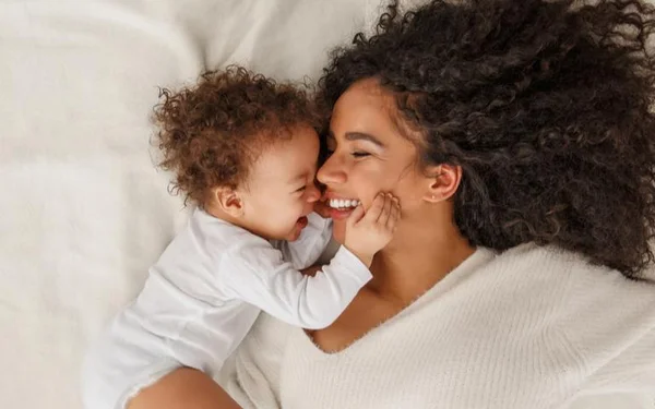 Bebê e mãe em cima da cama