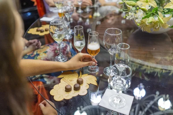 Taças, chocolates e espumantes em cima de uma mesa de vidro