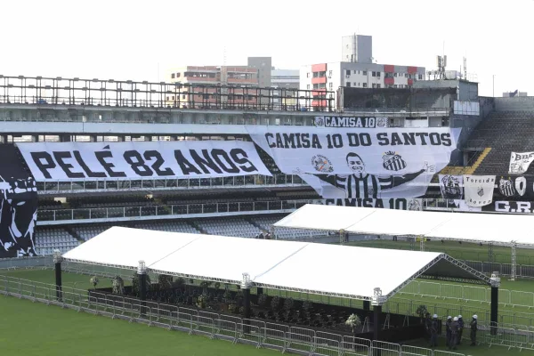Estrutura montada no campo da Vila Belmiro, estádio do Santos, para o velório do ex-jogador Pelé. Ao fundo, na arquibancada, é possível ver um bandeira com a silhueta do atleta e os dizeres "O rei Pelé" - Metrópoles