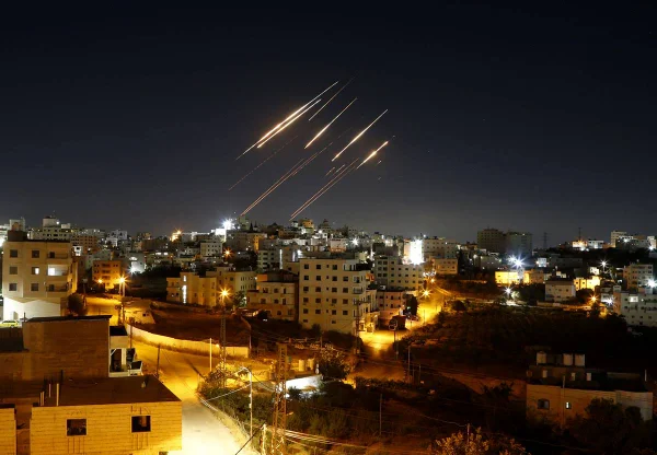 Imagem colorida, Rastros de luz de mísseis balísticos iranianos são vistos no céu noturno acima de Hebron, na Cisjordânia. - Metrópoles