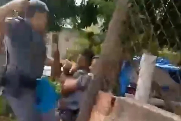 Imagem colorida mostra momento em que PM se prepara para socar suspeito imobilizado por outro policial - Metrópoles