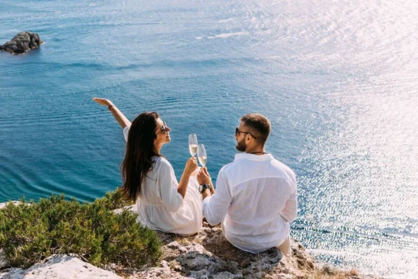 Casal brindando a beira mar
