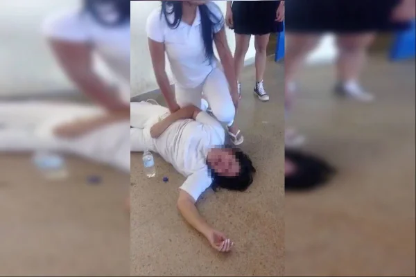 Mulher caída é auxiliada por outra mulher