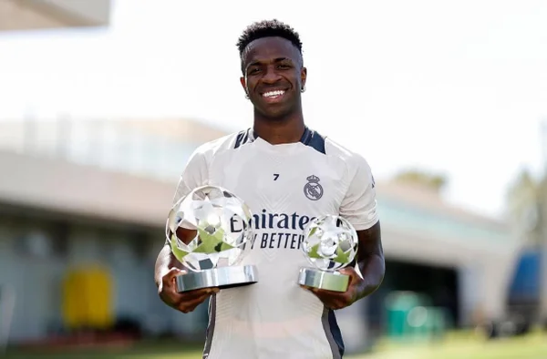 Imagem colorida de Vini Jr com prêmio de melhor jogador da Champions League- Metrópoles