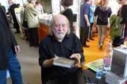 László Krasznahorkai segurando um livro
